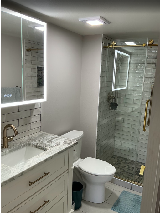 Renovated bathroom with marble tile and brass
